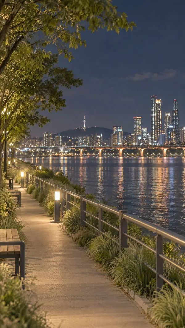 A path along the Han River with the city lights across the water